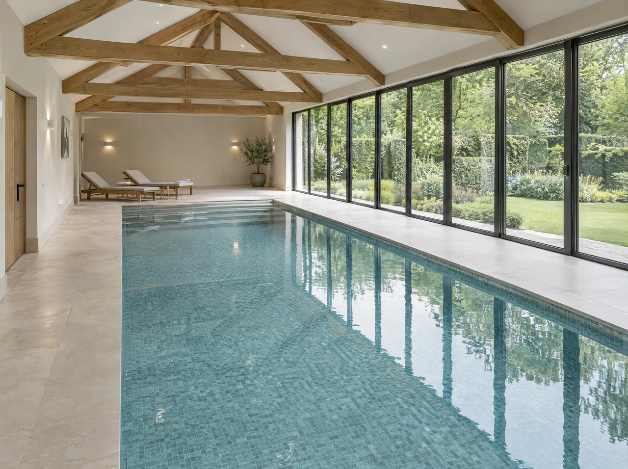 Indoor residential pool design with oak beams and full-height garden glazing